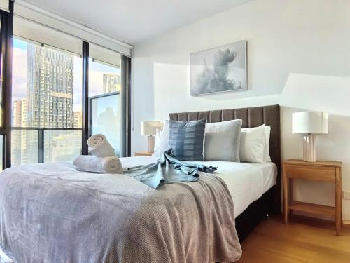 a bedroom with a large bed with a large window at Charming 1BR Southbank w balcony & free parking#TI22 in Melbourne