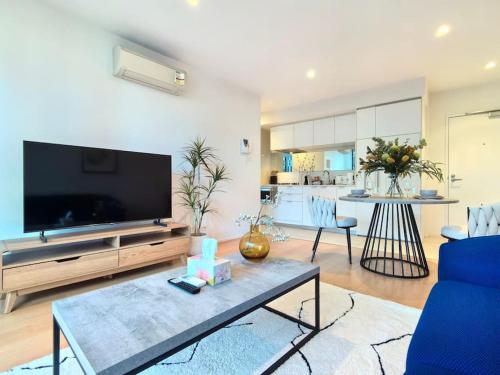 a living room with a large flat screen tv at Charming 1BR Southbank w balcony & free parking#TI22 in Melbourne