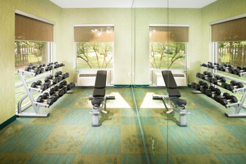 a gym with chairs and treadmills and windows at SpringHill Suites by Marriott Bentonville in Bentonville