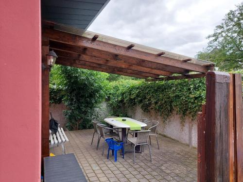 eine Terrasse mit einem Tisch und Stühlen unter einer hölzernen Pergola in der Unterkunft City-Pension Senftenberg / Apartment Nr. 3 in Senftenberg