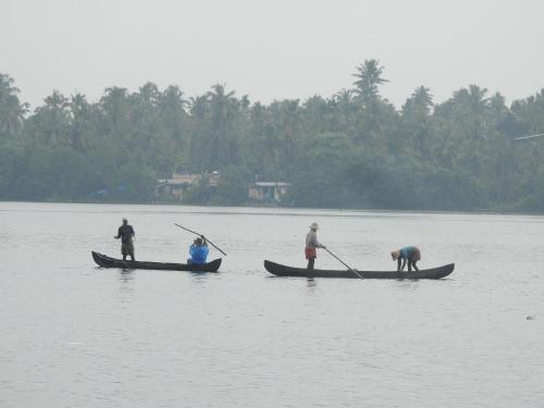 a group of three people in boats in the water at Lago Leisure Resort & Spa in Cherai Beach