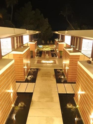 a view of a building with a pond at night at Lago Leisure Resort & Spa in Cherai Beach