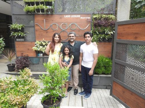 a family posing for a picture in a garden at Lago Leisure Resort & Spa in Cherai Beach