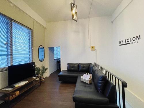 a living room with a couch and a tv at Tolomhouse in Hat Yai