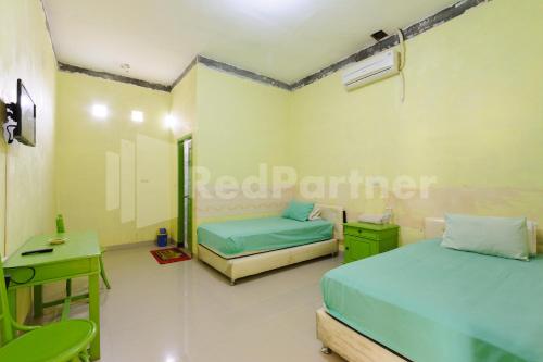 Negarasaka的住宿－Homestay Hj Suharti Natar Lampung RedPartner，一间医院间,配有两张床和一张书桌