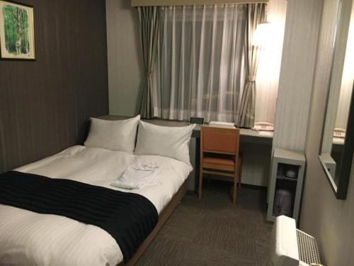 a hotel room with a bed and a desk at Tottori City Hotel / Vacation STAY 81351 in Tottori