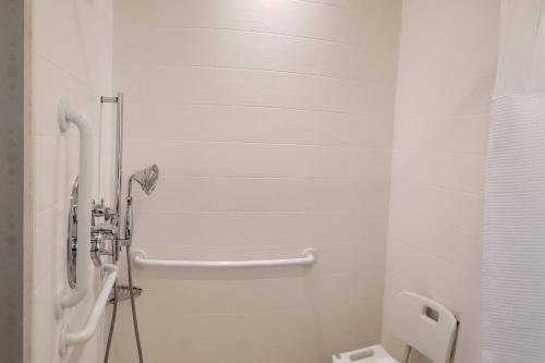 a white bathroom with a urinal and a toilet at SpringHill Suites by Marriott Grand Junction Downtown/Historic Main Street in Grand Junction