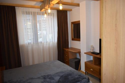 een slaapkamer met een bed en een raam bij Супер луксозен апартамент в Winslow in Bansko