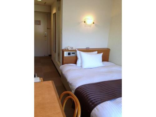 ein Hotelzimmer mit 2 Betten und einem Tisch in der Unterkunft Tottori City Hotel / Vacation STAY 81358 in Tottori