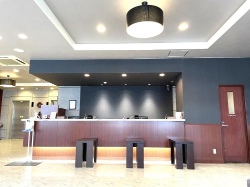 a waiting area of a hospital with a counter and stools at Hotel Route-Inn Niihama in Niihama