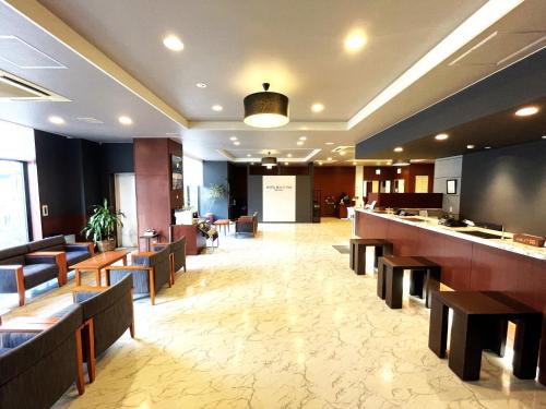 a lobby of a hotel with chairs and a bar at Hotel Route-Inn Niihama in Niihama