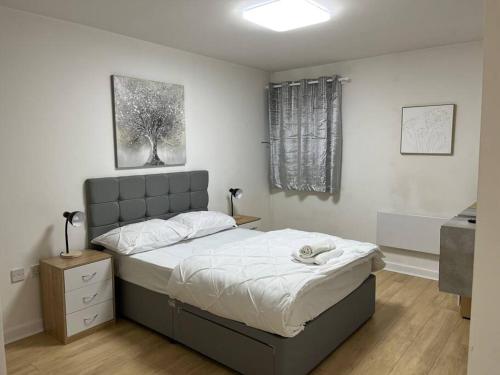 a bedroom with a large bed with white sheets at Cosy & sweet, 1bd Spacious By Media City in Manchester