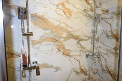 een badkamer met een marmeren muur en een douche bij Супер луксозен апартамент в Winslow in Bansko