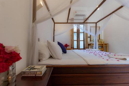 1 dormitorio con 1 cama con dosel en Chimaca Bay Hotel, en Arugam Bay