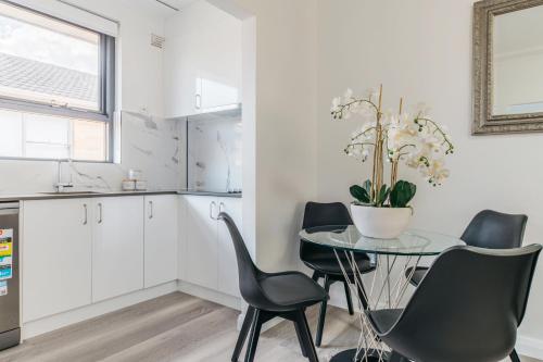 a kitchen with a table and chairs in a kitchen at Grace at Mosman - Serviced Apartments in Sydney