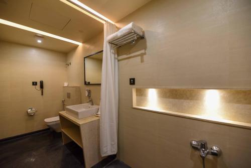 a bathroom with a sink and a toilet at Ayra Boutique Hotel in Bengaluru