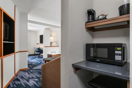 a hotel room with a microwave and a kitchen at Fairfield Inn & Suites by Marriott Chattanooga South East Ridge in Chattanooga