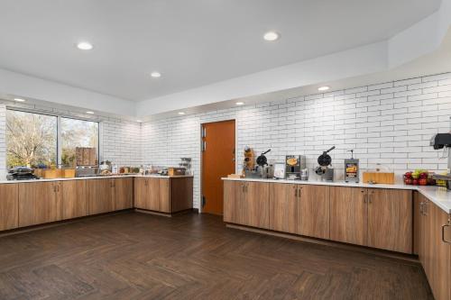 a large kitchen with wooden cabinets and white tiles at Fairfield Inn & Suites by Marriott Chattanooga South East Ridge in Chattanooga
