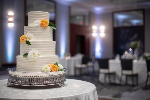 a white wedding cake with flowers on a table at JW Marriott Grand Rapids in Grand Rapids