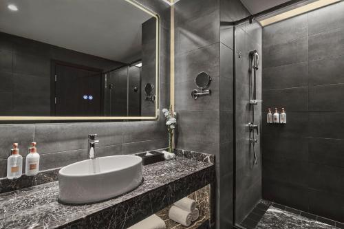 a bathroom with a sink and a shower at Crowne Plaza Shanghai Jinshan, an IHG Hotel in Jinshan
