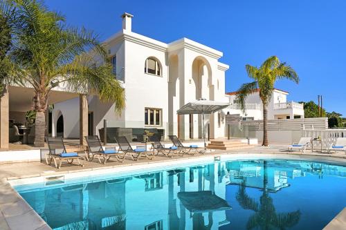 a swimming pool in front of a house at Villa Harmony in Protaras