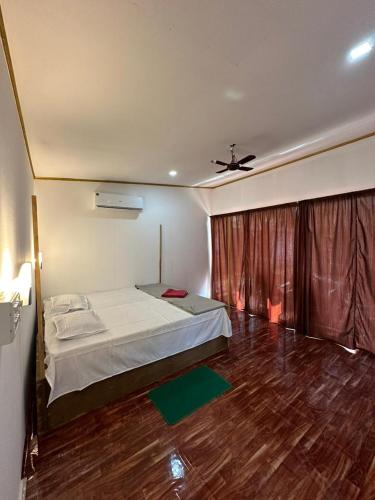 a bedroom with a bed and a ceiling fan at Mountain Palm patnem beach in Patnem