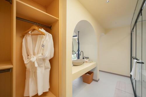 a bathroom with a white robe hanging on a wall at Dali Luyu Cliff Seaview Inn in Dali