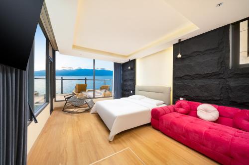 een slaapkamer met een bed en een rode bank bij Dali Luyu Cliff Seaview Inn in Dali