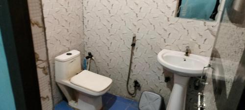 a small bathroom with a toilet and a sink at PRIYAMVADA FAMILY HOMESTAY in Vrindāvan