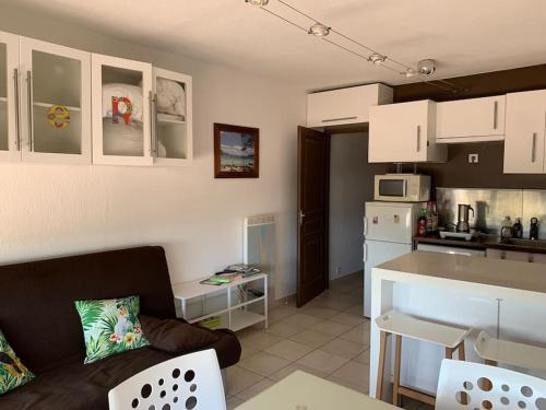 a living room with a couch and a kitchen at Belle vue sur mer avec place de parking in La Grande-Motte