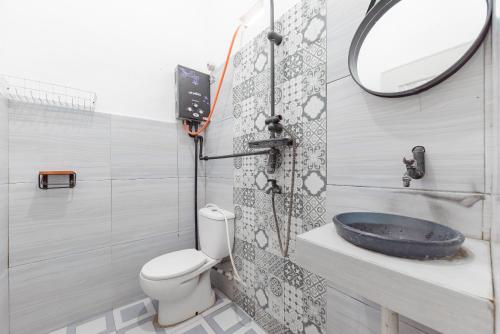 a bathroom with a toilet and a sink at RedDoorz @ Jalan Raya Tuparev Karawang in Karawang