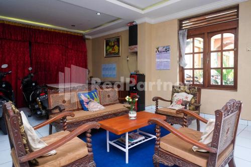a living room with a table and chairs at Hotel Sido Langgeng Tawangmangu Mitra RedDoorz in Karanganyar