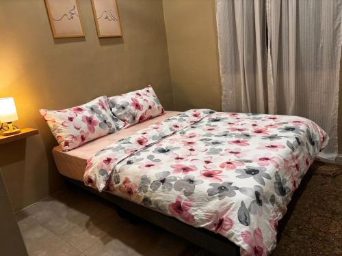 a bedroom with a bed with a flowered comforter at Reban at Sri Damai in Kuantan