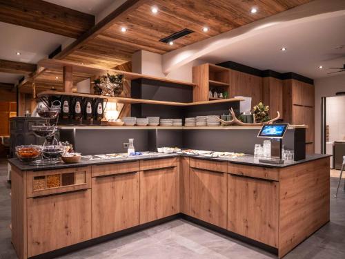 a kitchen with wooden cabinets and a counter top at Central Hotel & Apart mit Landhaus Central in Fügen