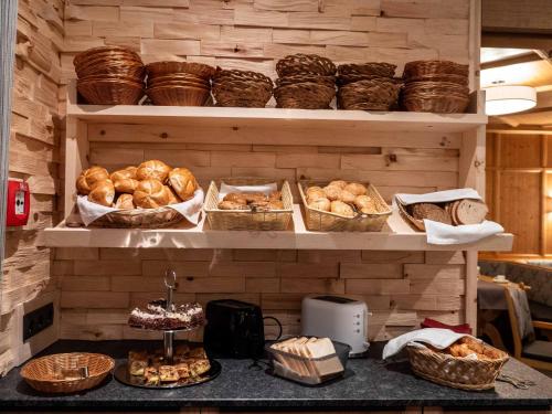 a shelf filled with lots of bread and baskets at Central Hotel & Apart mit Landhaus Central in Fügen