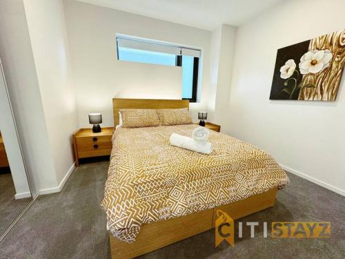 une chambre avec un lit avec une couette dessus dans l'établissement Lavish in Lyneham - 2BD 1Bth Apt, à Canberra