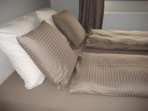 a bed with pillows and pillows on top of it at Nobel in Westende