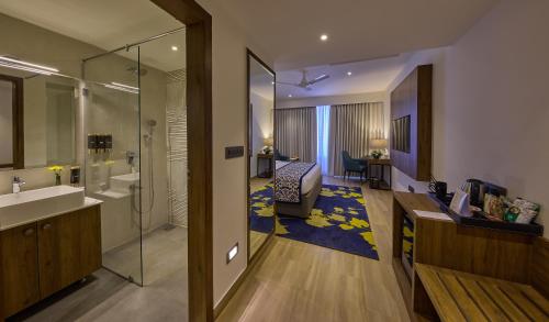 uma casa de banho com um lavatório e um quarto em Grand Continent Hebbal A Sarovar Portico Affiliate Hotel em Bangalore