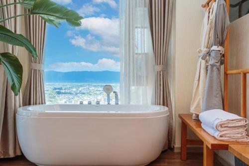 a bath tub in a bathroom with a window at Dali Ink Inn in Dali