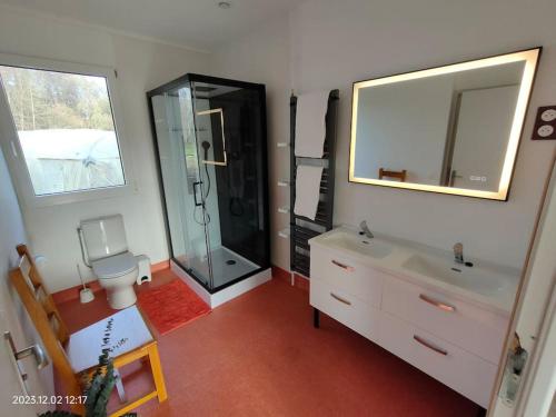 een badkamer met een douche, een wastafel en een toilet bij Maison calme à la campagne 