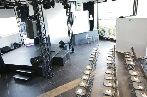 a room with rows of chairs and a stage at hôtel QUICK Palace Tours Nord in Tours