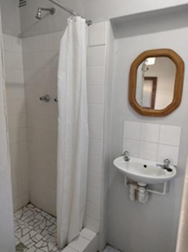 a bathroom with a shower curtain and a sink at Stonehenge Cottage in Oudtshoorn