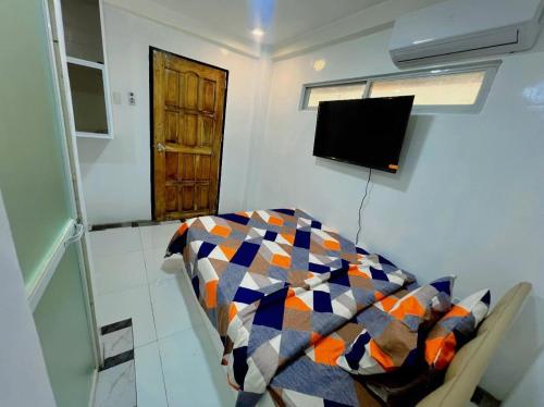 um quarto com uma mesa e uma televisão na parede em Aloha Cabana Resort And Events em Surigao