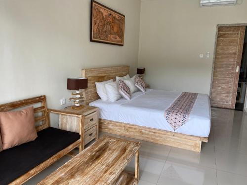 a bedroom with two beds and a table and a chair at Green D'mel Bali in Nusa Dua