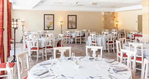 a dining room with white tables and chairs at Avignon Grand Hotel in Avignon
