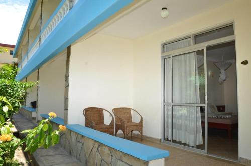 a patio of a house with chairs and a balcony at ASINS HOLIDAY INN HOTEL in Ukunda