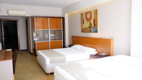 SalihliにあるHotel La Bella Salihliのベッド2台とデスクが備わるホテルルームです。