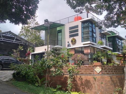 a house with a brick wall in front of it at Villa Omahe Dewe by Da- hee in Bandungan