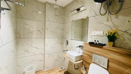 a bathroom with a sink and a toilet in it at Travellers Hotel in New Delhi