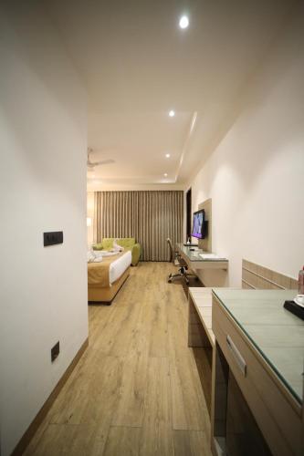 a hotel room with a bed and a desk at HOTEL LE SEASONS PARK in Greater Noida